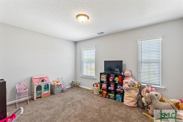 rec room featuring visible vents, carpet floors, a textured ceiling, and baseboards