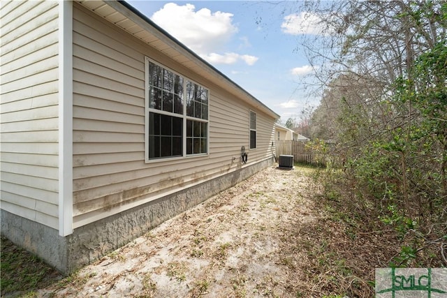 view of home's exterior featuring cooling unit and fence