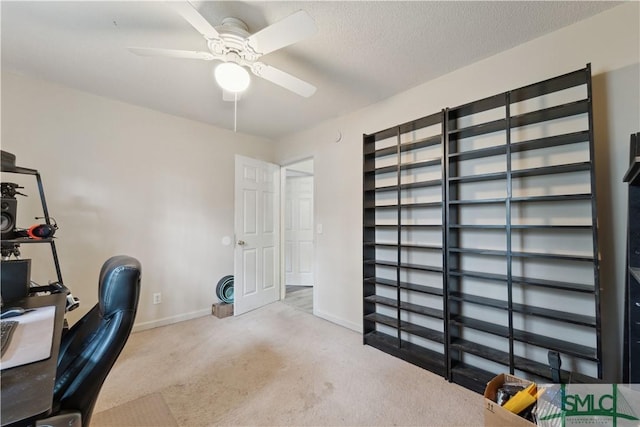 carpeted office with baseboards, a textured ceiling, and ceiling fan