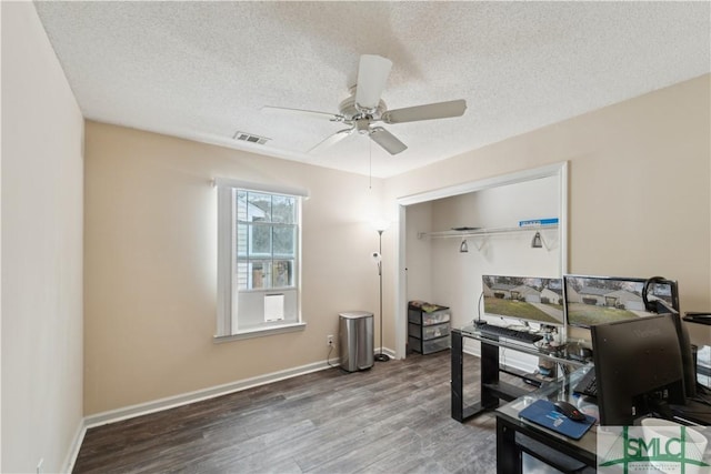 home office featuring ceiling fan, wood finished floors, visible vents, and baseboards