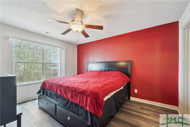 bedroom featuring wood finished floors, baseboards, and a textured ceiling