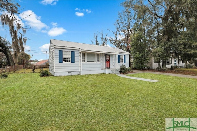 view of front of home featuring a front yard, metal roof, fence, and crawl space