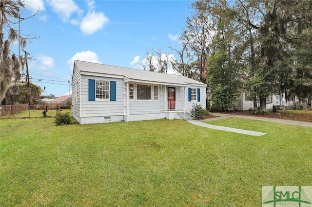 view of front of house with crawl space, metal roof, a front lawn, and fence