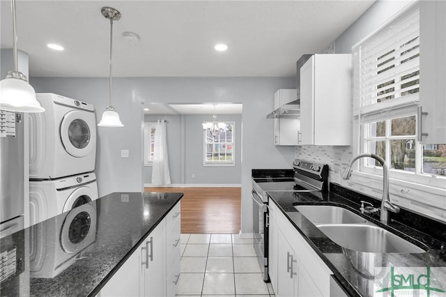 kitchen featuring backsplash, electric range, white cabinets, stacked washer / drying machine, and a sink