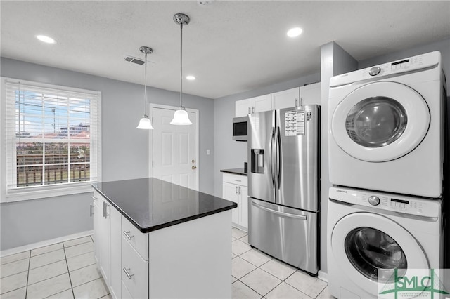 washroom featuring light tile patterned floors, visible vents, stacked washer and dryer, and recessed lighting
