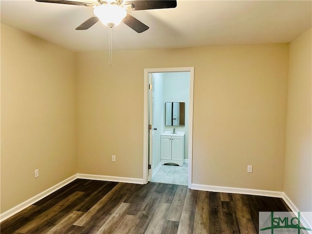 spare room featuring baseboards and dark wood finished floors