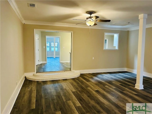 empty room with baseboards, dark wood-style floors, visible vents, and ornamental molding