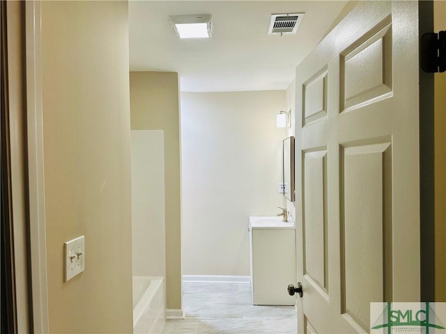 full bathroom featuring visible vents, a tub, vanity, and baseboards