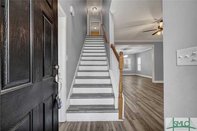 entrance foyer with stairway, crown molding, baseboards, and wood finished floors