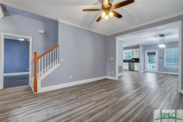 unfurnished living room with a wealth of natural light, baseboards, wood finished floors, and stairs