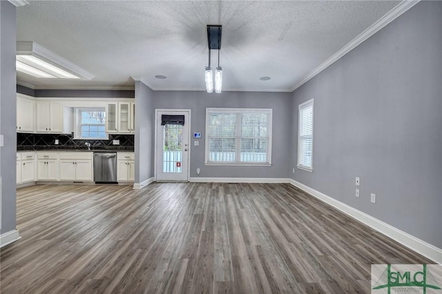 interior space featuring tasteful backsplash, dark countertops, dishwasher, and wood finished floors