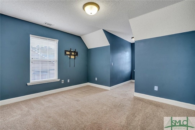 bonus room with visible vents, baseboards, vaulted ceiling, carpet flooring, and a textured ceiling