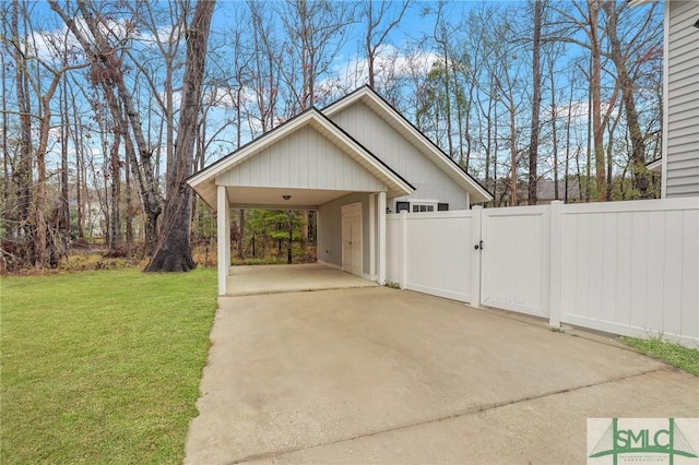 exterior space with an attached carport, driveway, fence, and a gate