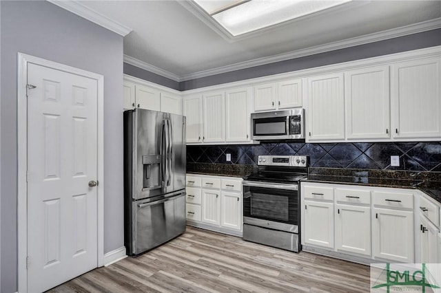 kitchen featuring light wood-style flooring, white cabinets, appliances with stainless steel finishes, crown molding, and tasteful backsplash