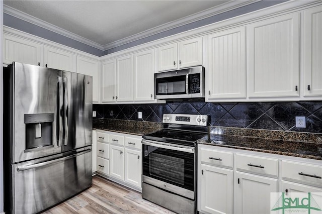 kitchen featuring white cabinets, tasteful backsplash, light wood finished floors, and stainless steel appliances