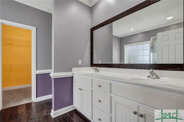 full bathroom with ornamental molding, wood finished floors, and a sink