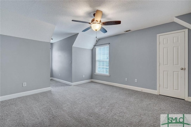 additional living space featuring visible vents, carpet floors, a ceiling fan, and vaulted ceiling