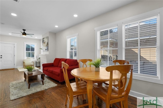 dining room featuring recessed lighting, baseboards, plenty of natural light, and dark wood-style flooring