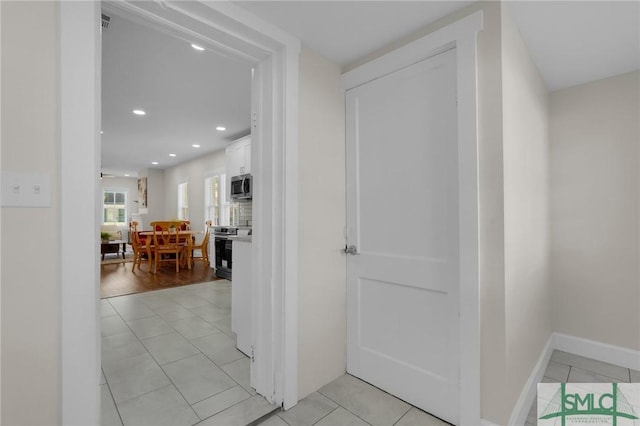 hallway featuring light tile patterned floors, recessed lighting, and baseboards