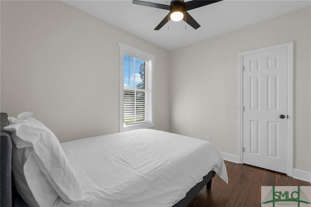 bedroom featuring dark wood finished floors, a ceiling fan, and baseboards