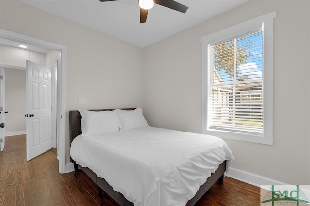 bedroom featuring multiple windows, ceiling fan, baseboards, and wood finished floors