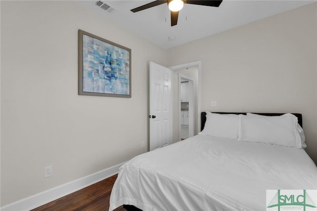 bedroom featuring a ceiling fan, dark wood-style floors, visible vents, and baseboards