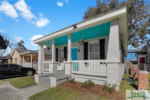 view of front facade with covered porch and stucco siding