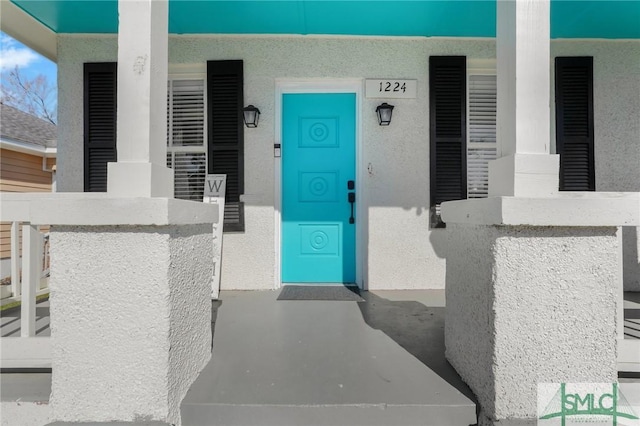 view of exterior entry featuring stucco siding