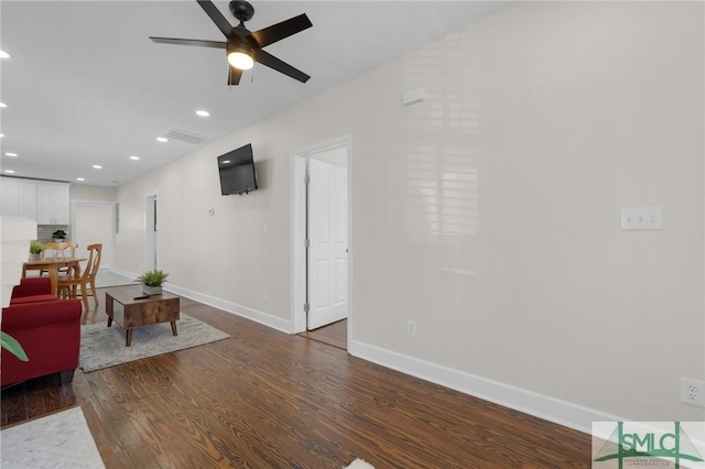 living area featuring recessed lighting, a ceiling fan, baseboards, and wood finished floors