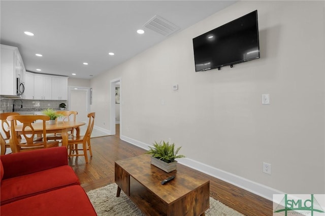 living area with recessed lighting, visible vents, baseboards, and light wood-style floors