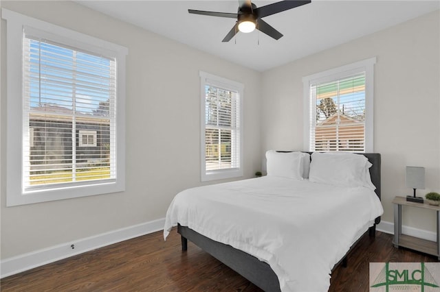 bedroom with multiple windows, a ceiling fan, baseboards, and dark wood-style flooring