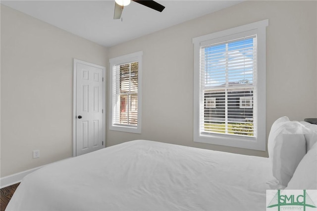 bedroom with a ceiling fan and baseboards