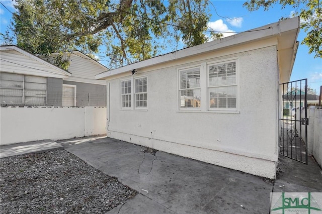 view of side of home with a patio and fence