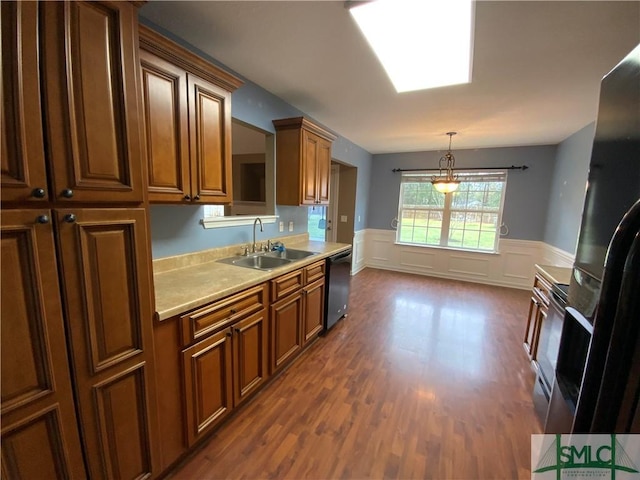 kitchen with dark wood-type flooring, a sink, black fridge with ice dispenser, light countertops, and dishwashing machine