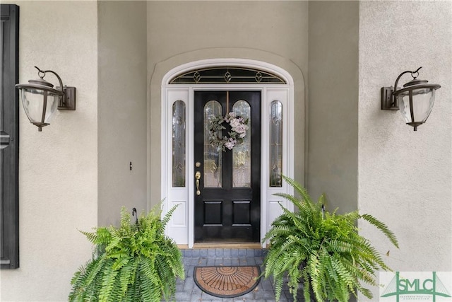 doorway to property featuring stucco siding