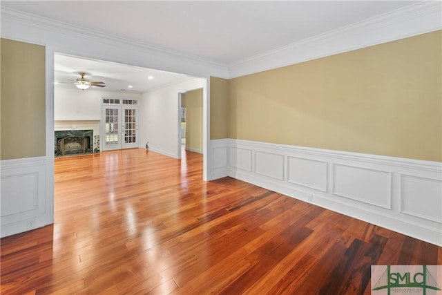 unfurnished living room featuring light wood-style flooring, a fireplace, and ornamental molding