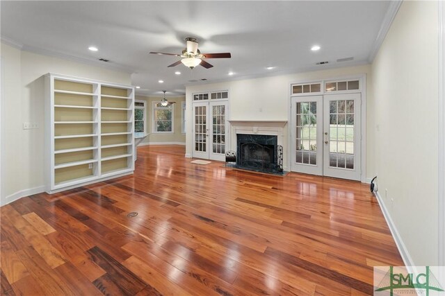 unfurnished living room with wood finished floors, baseboards, recessed lighting, french doors, and crown molding