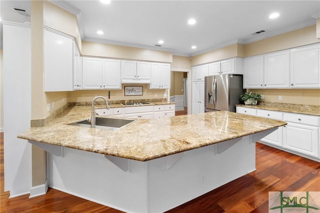 kitchen with a peninsula, dark wood-style flooring, a sink, cooktop, and stainless steel refrigerator with ice dispenser