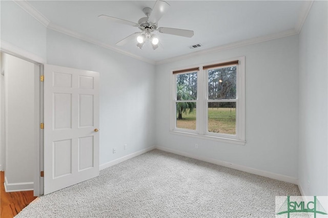 spare room featuring visible vents, a ceiling fan, baseboards, and ornamental molding