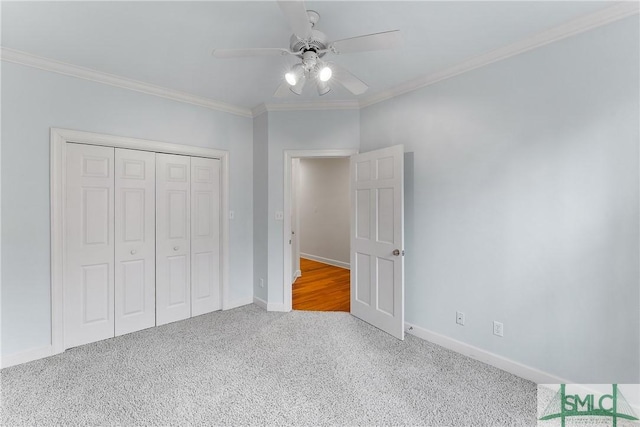 unfurnished bedroom with a closet, baseboards, ornamental molding, and carpet flooring