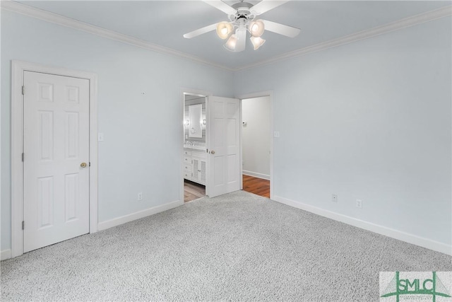 unfurnished bedroom featuring baseboards, carpet floors, ensuite bath, and crown molding