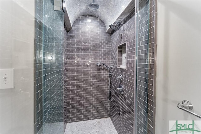 full bath featuring a stall shower and lofted ceiling