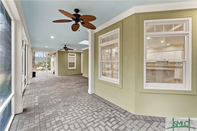 unfurnished sunroom with ceiling fan