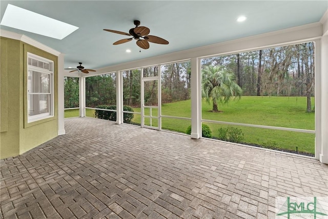 unfurnished sunroom with a skylight and ceiling fan