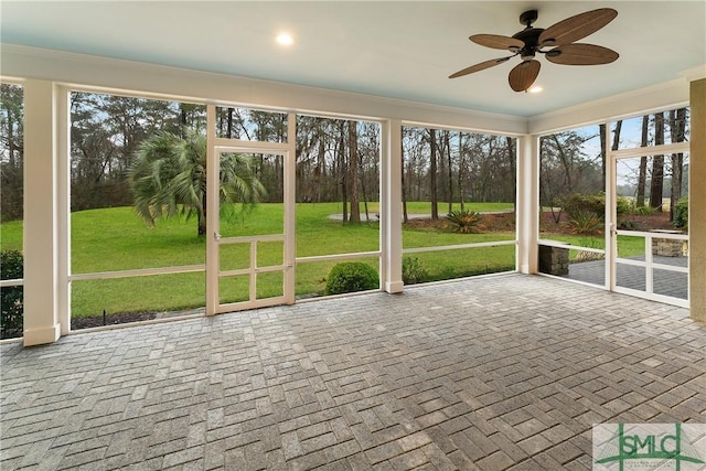 unfurnished sunroom with ceiling fan