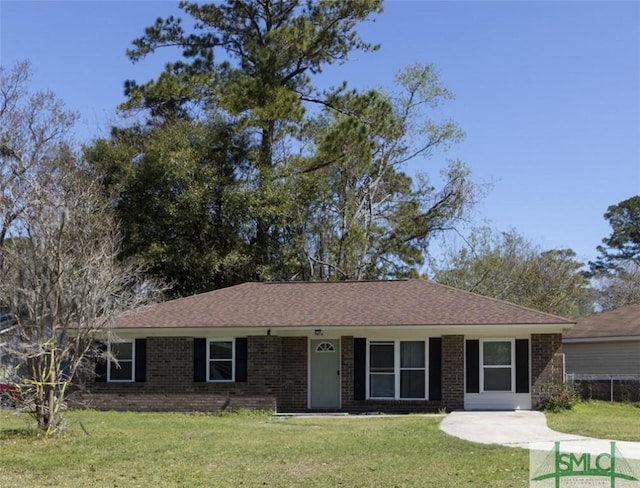 ranch-style home with a front yard, brick siding, and a shingled roof