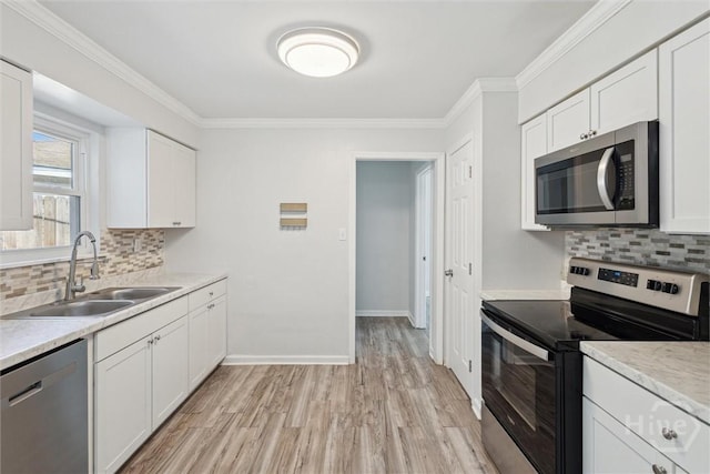 7014 Key St, Savannah, GA 31406 - kitchen with stainless steel appliances, a sink, light wood-type flooring, backsplash, and white cabinets