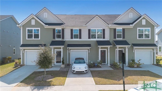 view of property with a garage, board and batten siding, and driveway