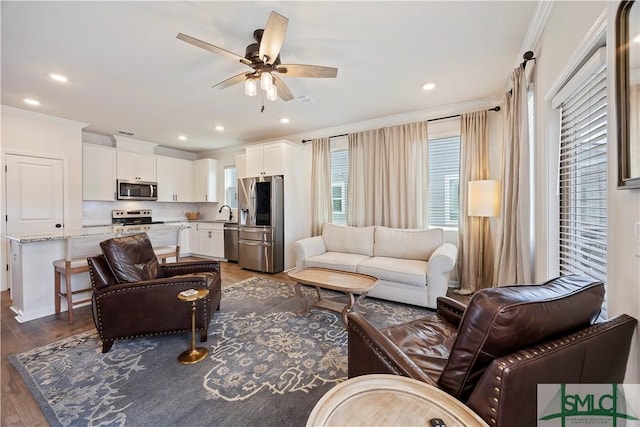 living area with crown molding, recessed lighting, wood finished floors, and ceiling fan