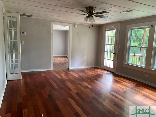 empty room with visible vents, a ceiling fan, baseboards, and wood finished floors